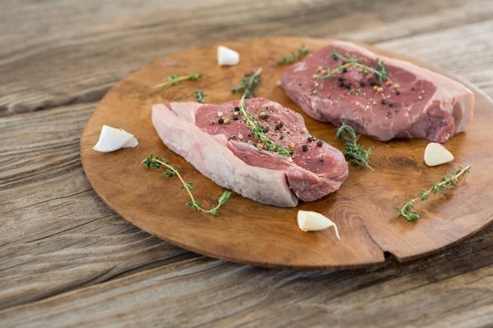 Sirloin steak, garlic and herb on wooden tray