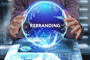 Business, Technology, Internet and network concept. Young businessman shows the word on the virtual display of the future: Rebranding