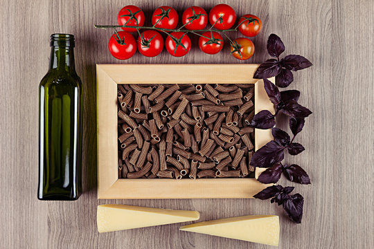 Ingredients Italian pasta in wood frame on beige wooden board  as decorative picture background. Mock up restaurant menu.