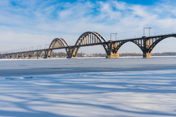 Winter landscape with Merefo-Hersonsky bridge over frozen Dnepr river on the same city, Ukraine © Yuri Kravchenko