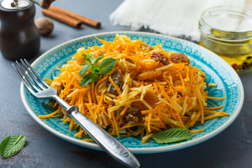 Vegetarian salad with pumpkin, apples and raisins on a dark background. Selective focus.