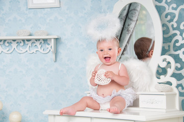Little angel smiling and sitting on the dressing table