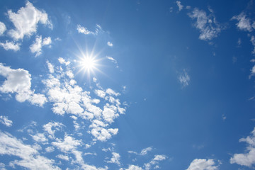 Blue sky with clouds and sun reflection. looking up view