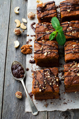 Chocolate brownie with a pumpkin on a old wooden background. Homemade Cake square pieces. Selective focus.top view.