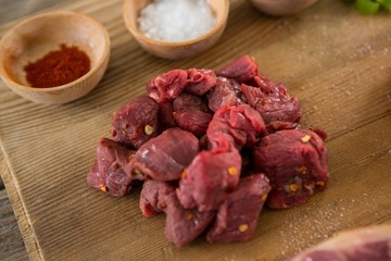 Diced beef and spices on wooden tray
