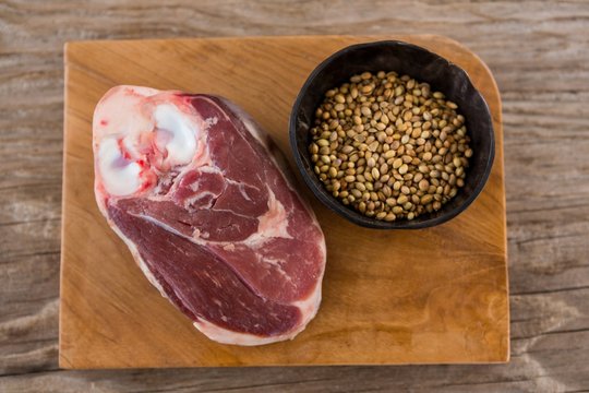 Sirloin chop and coriander seeds on wooden tray