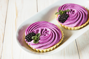 Homemade mini tarts with fresh berries currant pink cream and blackberries