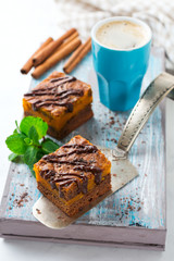 Chocolate brownie with a pumpkin on a light background. Selective focus.