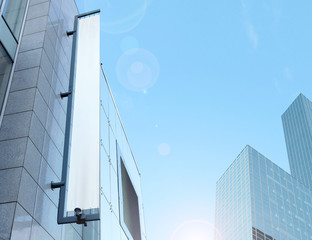 Blank white vertical banner on building facade, design mockup. Store flag mock up on the street....