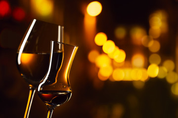  glasses with white wine and liquor on a background of night city