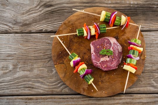 Sirloin chop with skewered vegetables on wooden tray