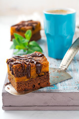 Chocolate brownie with a pumpkin on a light background. Selective focus.