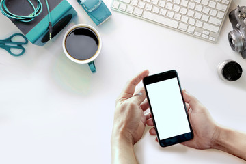 Man using smartphone on White office desk table. Top view with copy space, flat lay or hero header concept.