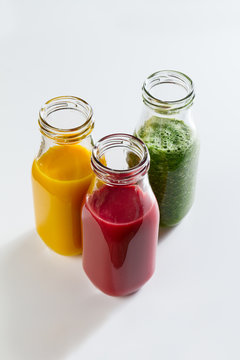 Tasty colorful fresh homemade smoothies in glass jars on bright background. Closeup. Healthy life, detox Concept.