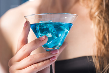 partial close up view of woman holding in hand cocktail drink