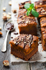 Fototapeta na wymiar Chocolate brownie with a pumpkin on a old wooden background. Homemade Cake square pieces. Selective focus.