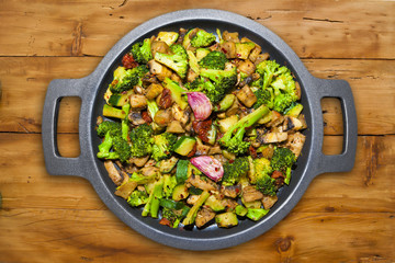 POT WITH VEGETABLES IN A WOODEN TABLE