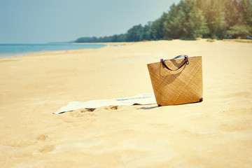 Summer vacation. Beach bag on sand near the sea.