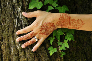 Indian henna tattoo on woman's arm and hand