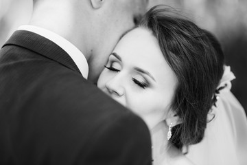 Close up tender portrait of lovely wedding couple. Black and white photo.