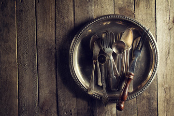 Vintage Old Rustic Kitchen Utensils Forks Spoons and Knifes on Old Wooden Table. Food or Vintage Rustic Concept. Top View.