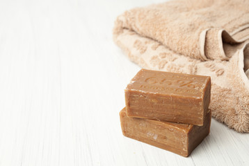 two pieces of household soap 65% and a towel on white