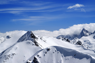 Obraz premium Winter mountains with snow cornice and blue sky with clouds in nice winter day