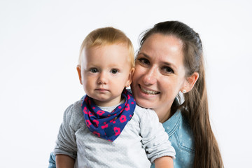 Beautiful mother with baby daughter in her arms. Studio shot.