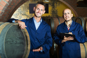 Fototapeta na wymiar Wine makers in winery cellar