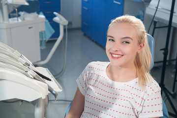 blonde girl smiling in a dentist's office
