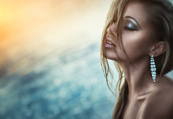 sexy and sensual woman with jewelry near the sea, outdoor glamour photography, makeup