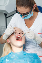 The dentist examines the patient using mirror