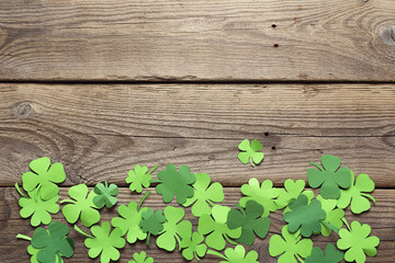 Paper clover leaves on the old wooden background. Lucky shamrock. Space for text. © WindyNight