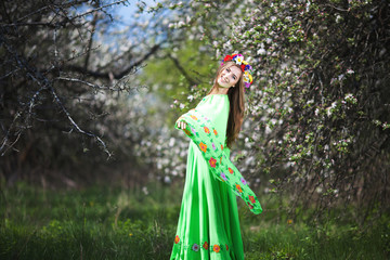 Plakat Portrait of beautiful natural smiling woman in nice green dress in the garden of apple