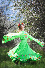 Fototapeta na wymiar Portrait of beautiful natural smiling woman in nice green dress in the garden of apple