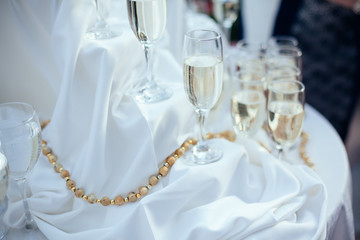 Dish with champagne and wine glasses. On outdoor wedding reception in summer.