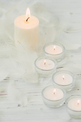 Fototapeta na wymiar white palm candle with natural decoration for spa on white wooden table