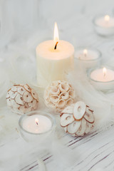 Fototapeta na wymiar white palm candle with natural decoration for spa on white wooden table