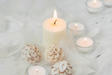 white palm candle with natural decoration for spa on white wooden table