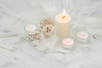 white palm candle with natural decoration for spa on white wooden table