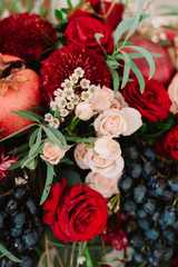 Autumnal wedding composition of roses, apples, grape and pomergranate