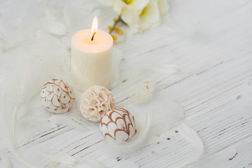 white palm candle with natural decoration for spa on white wooden table