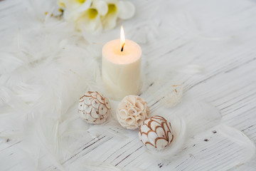Obraz na płótnie Canvas white palm candle with natural decoration for spa on white wooden table