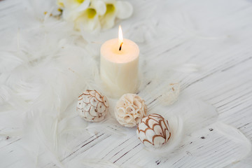 white palm candle with natural decoration for spa on white wooden table