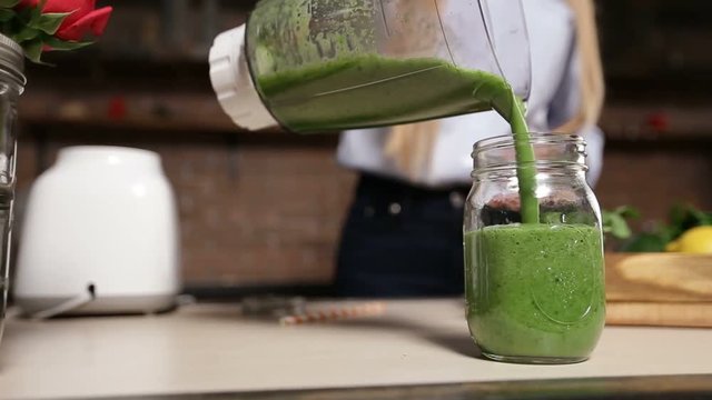 Pouring Fresh Green Smoothie From Blender Into Jar