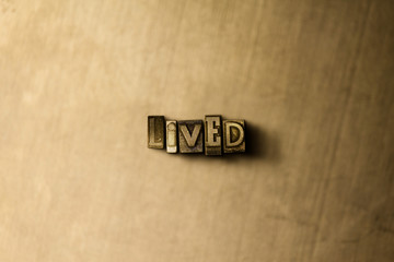 LIVED - close-up of grungy vintage typeset word on metal backdrop. Royalty free stock illustration.  Can be used for online banner ads and direct mail.