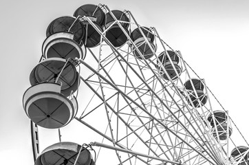 old Ferris wheel with colored cabins open against the blue sky