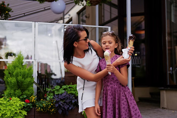 Fototapeta premium Two girls eating ice cream on a street.
