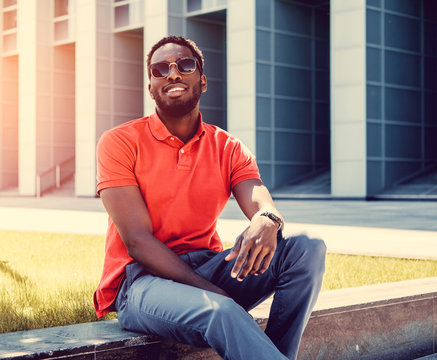 Smiling Black male dressed in a red polo shirt.