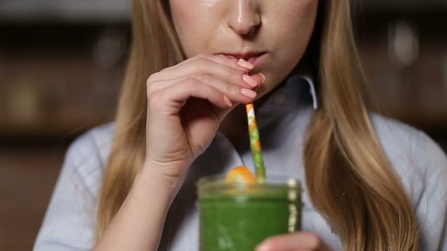 Woman drinking green detox vegetable smoothie